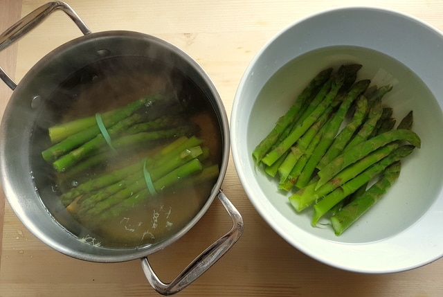 Poached salmon and asparagus lasagne al forno boiled asparagus in saucepan and white bowl