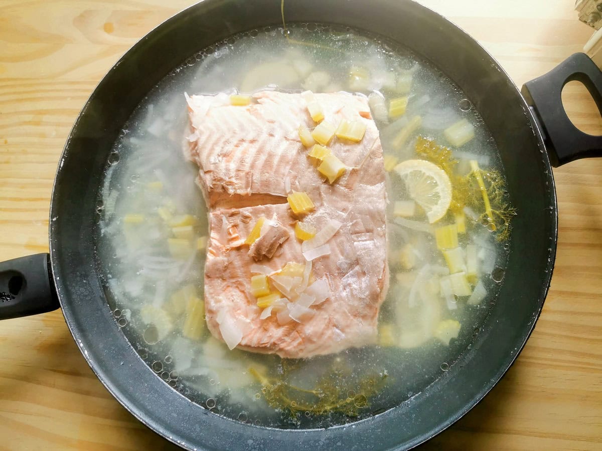 Ready poached salmon in poaching pan.