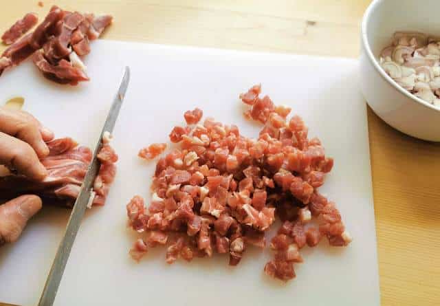 cutting the thick ham slices into small pieces