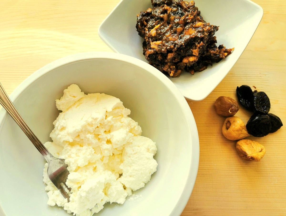 Dried fruit mixture and ricotta on a table.