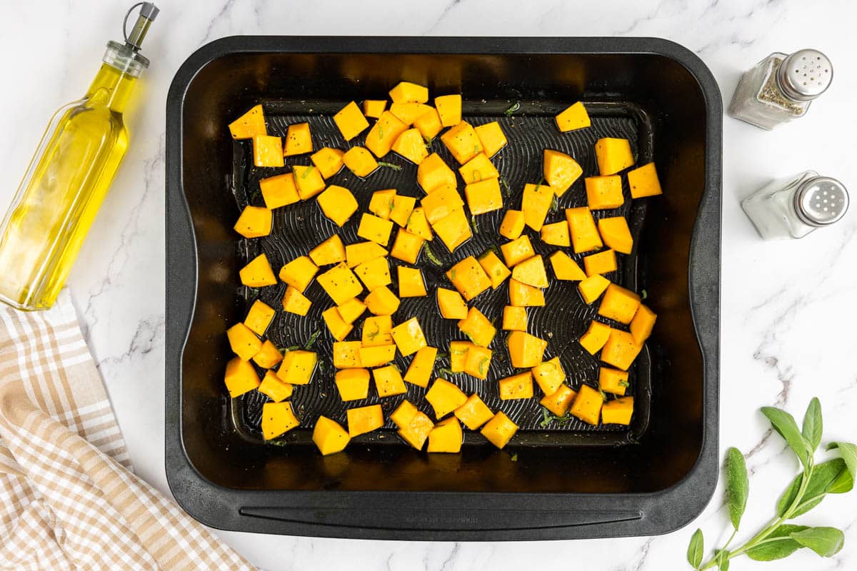 Cubed pumpkin with extra virgin olive oil, sea salt, pepper and chopped fresh sage