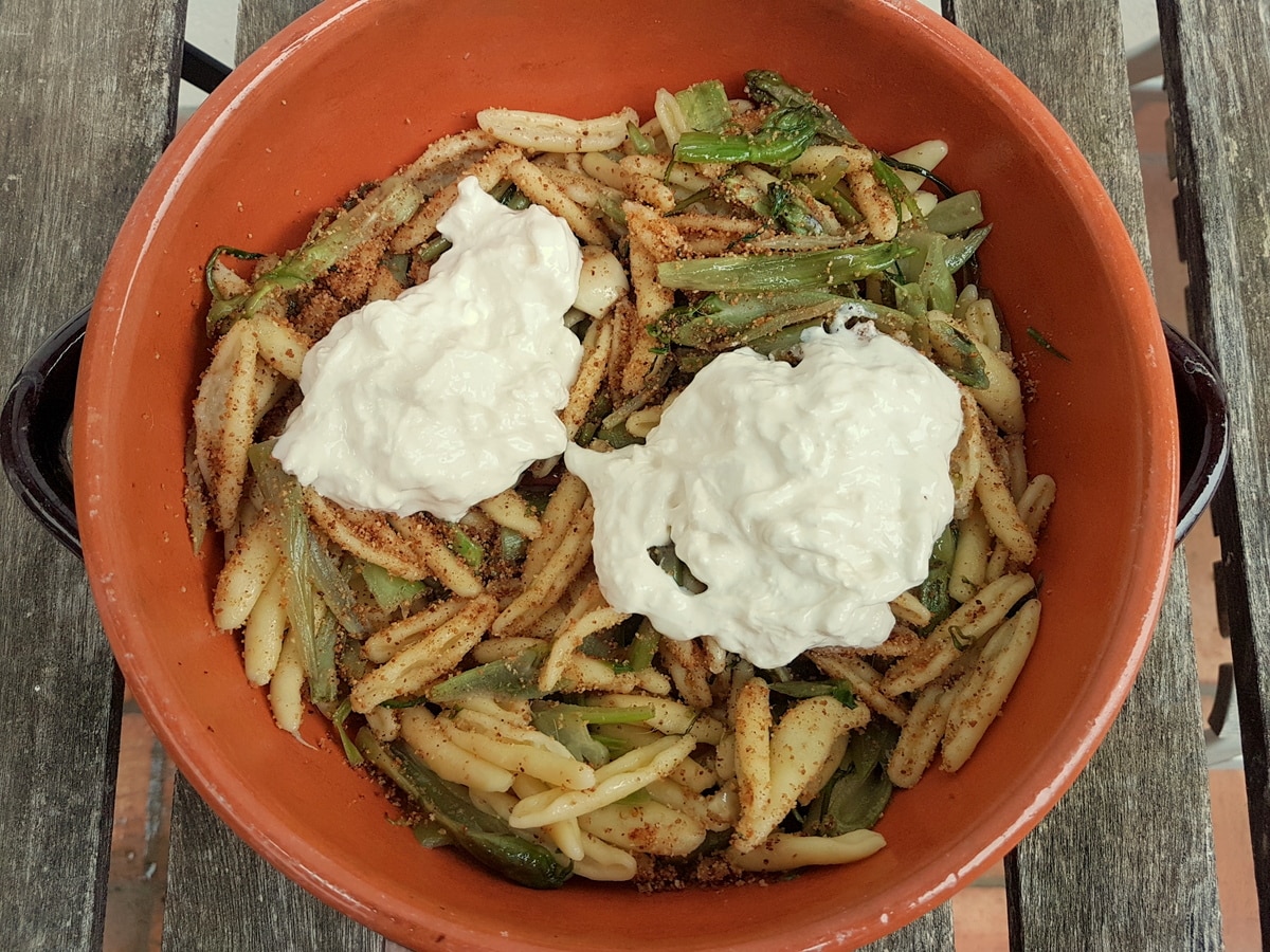 Puntarelle pasta with burrata and breadcrumbs in a bowl.