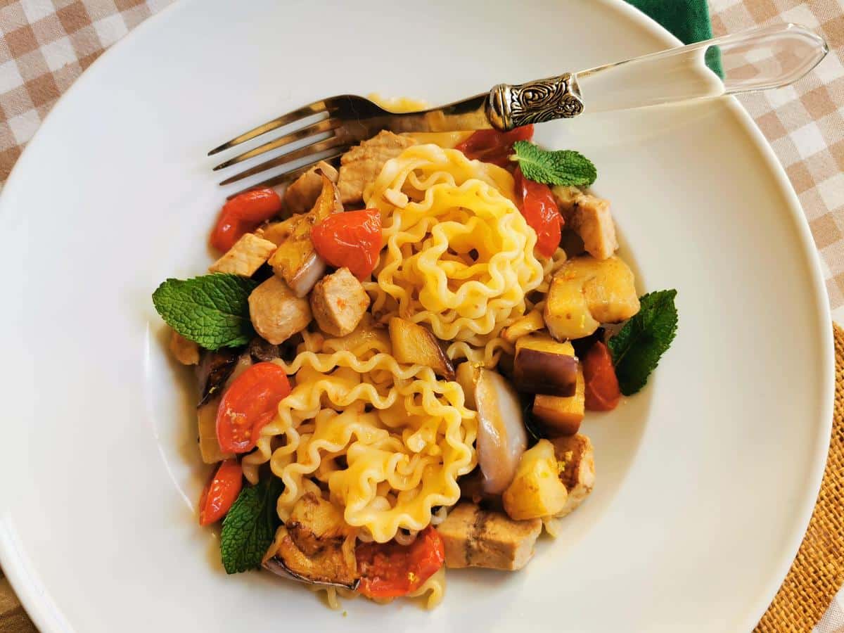 Malfadine pasta with swordfish, eggplant and cherry tomatoes in a bowl.