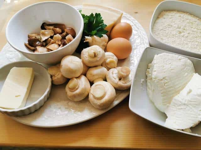 ingredients for ricotta gnocchi with mushrooms on white plate