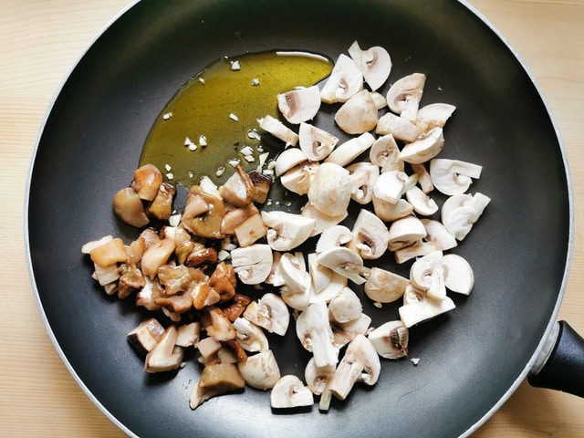 mushrooms pieces, garlic and olive oil in frying pan