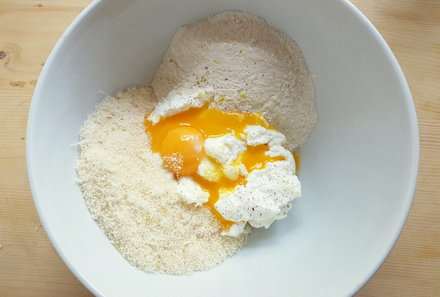 Ricotta, flour, Parmesan and eggs in white bowl