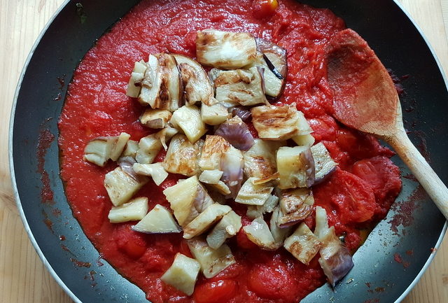 tomato sauce and pieces of fried eggplant in frying pan