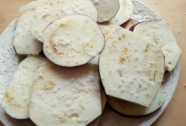 eggplant slices covered in salt to draw out liquid