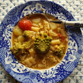 Romanesco broccoli pasta soup in blue and white bowl