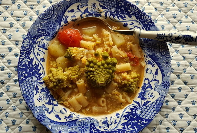 Romanesco broccoli pasta soup in blue and white bowl