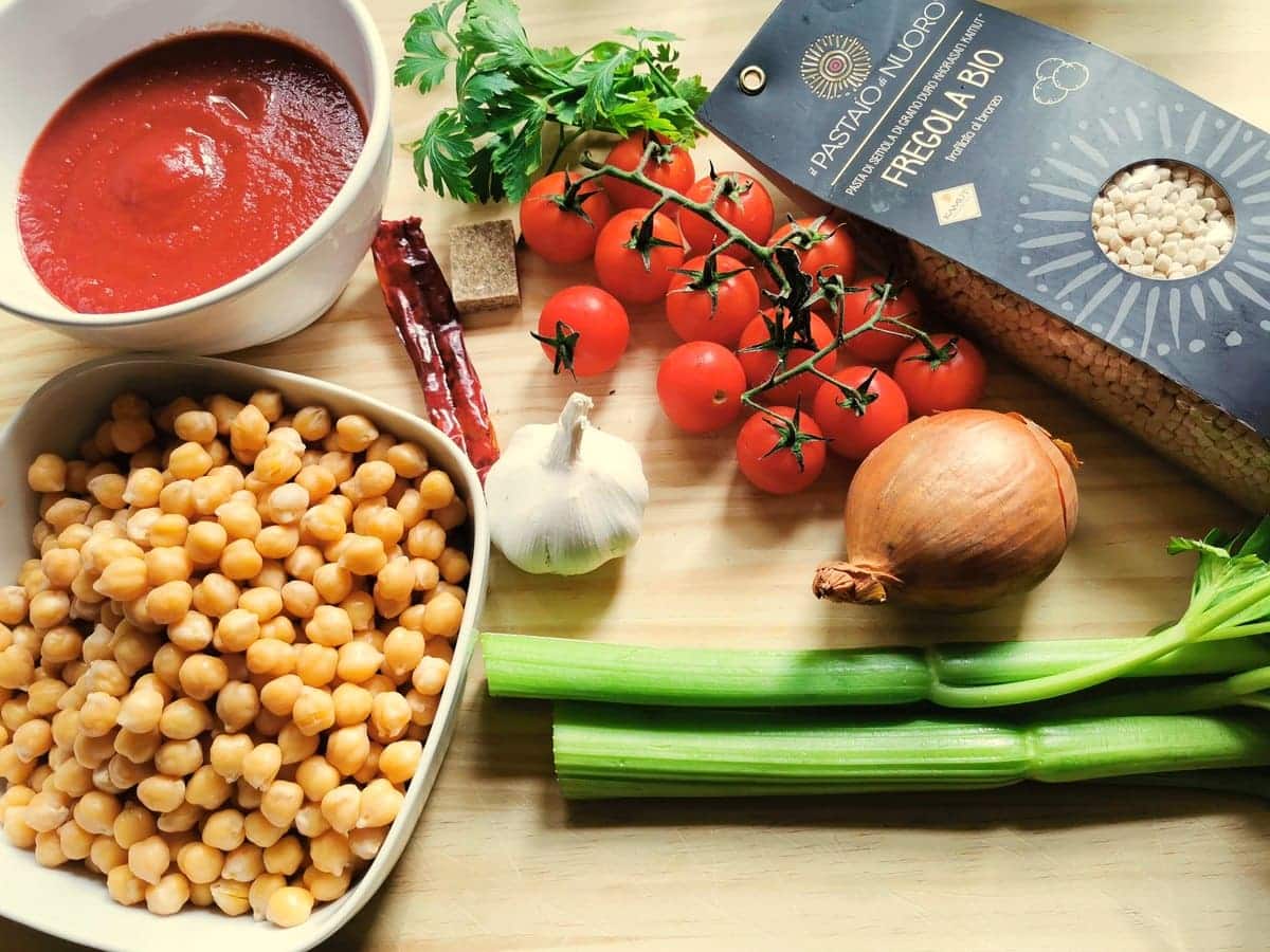 Ingredients for fregola with chickpeas on wood wrok surface.