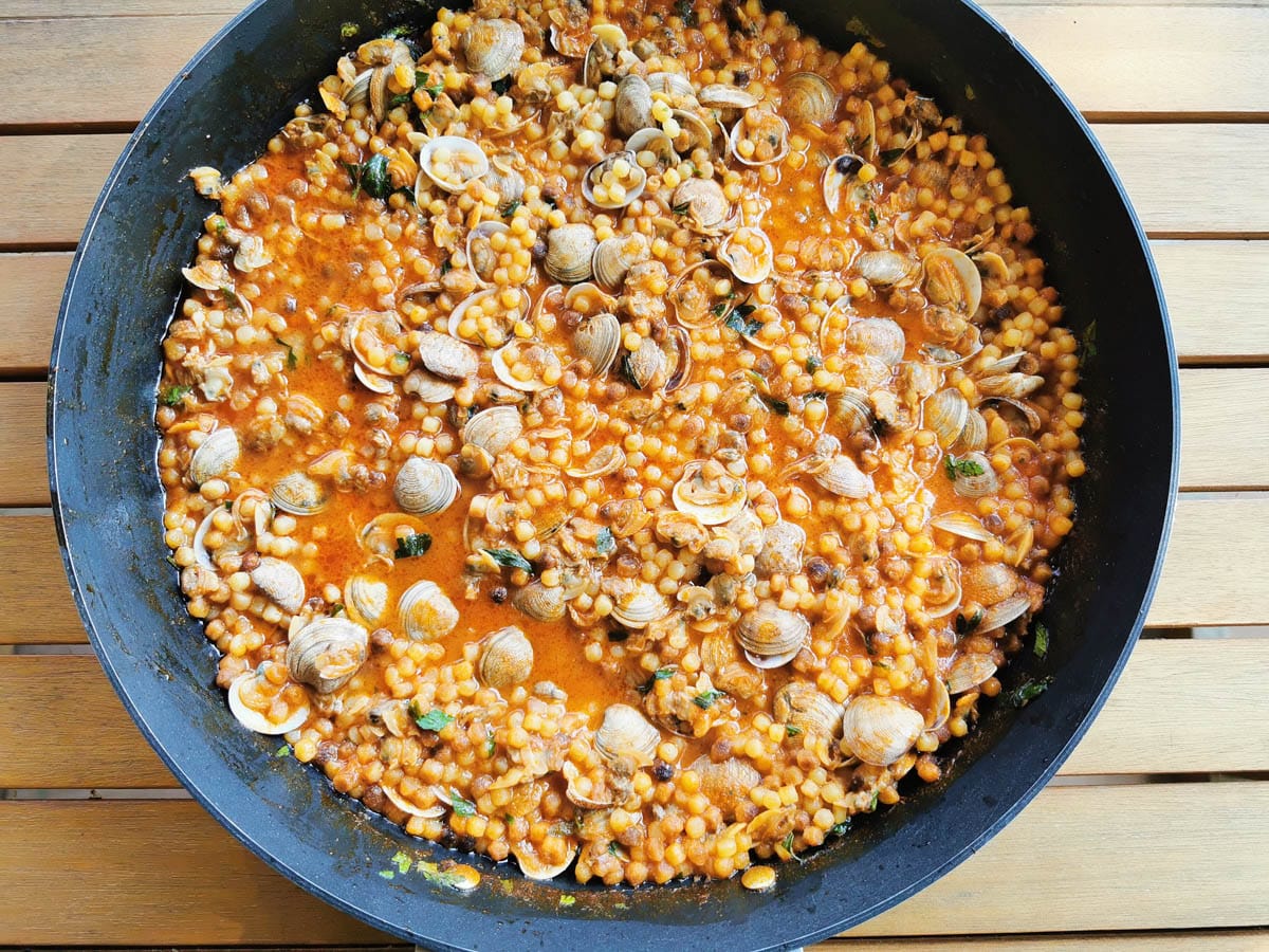 Fregola with clams in a saute pan