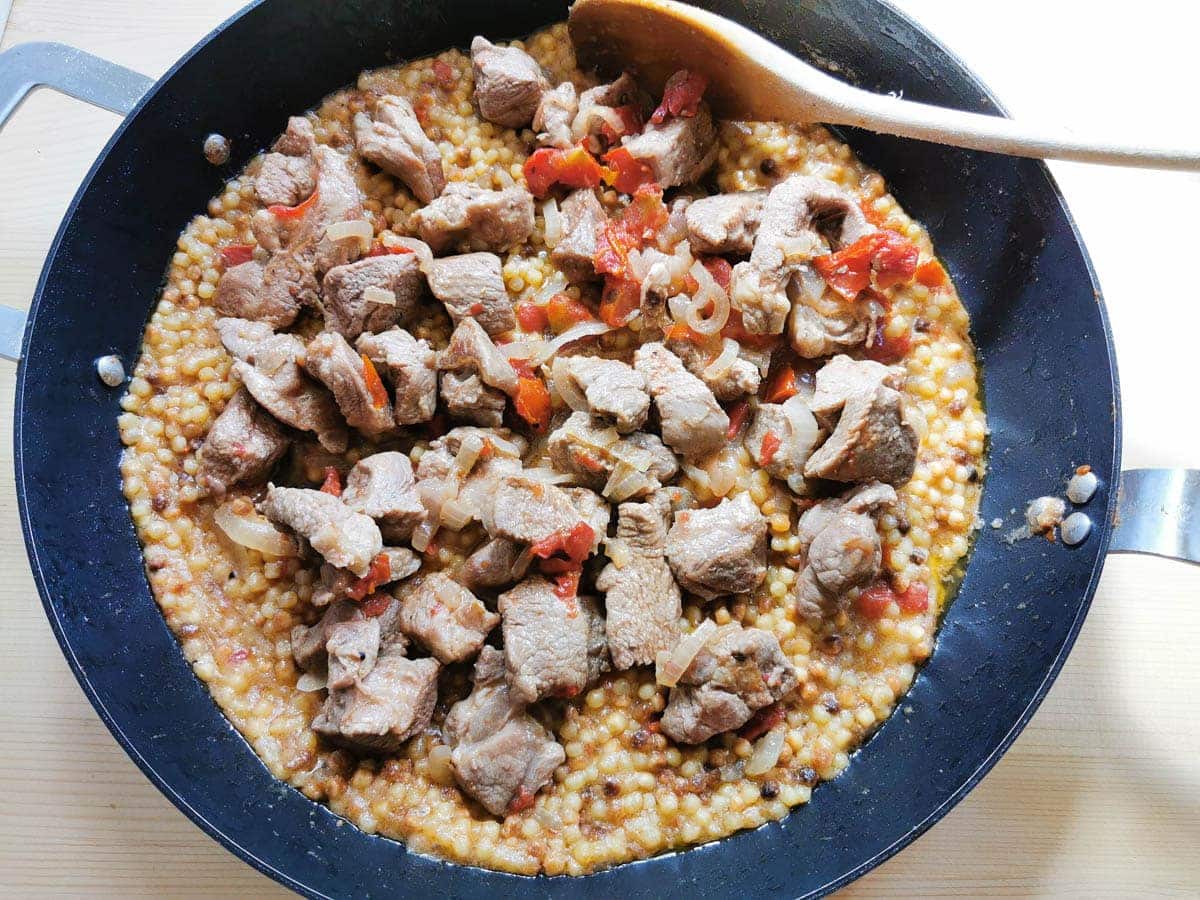 Lamb with fregola in a skillet