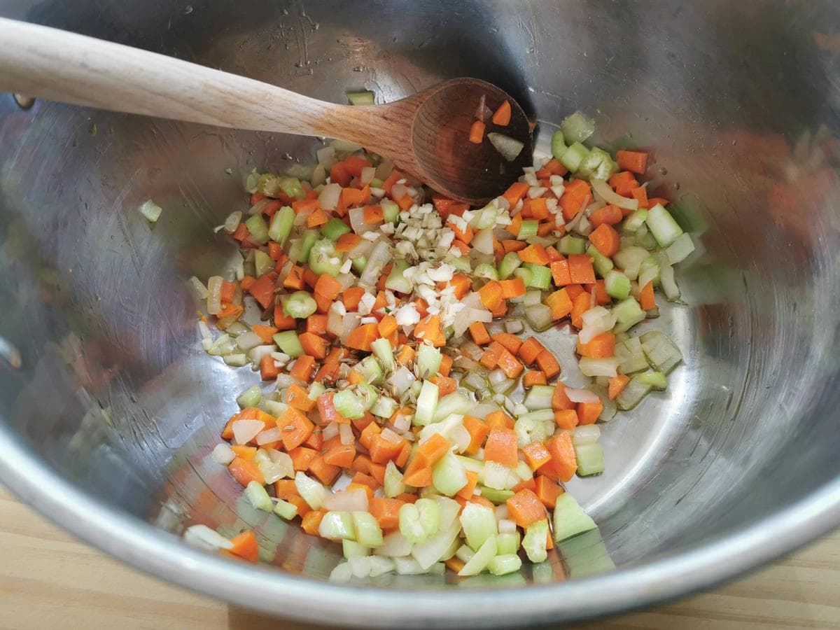 Chopped carrots, celery and onion sautéeing in large pot with garlic and fennel seeds.