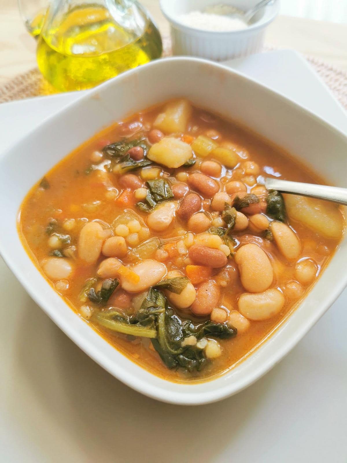 Sardinian longevity minestrone soup with fregola in white bowl.