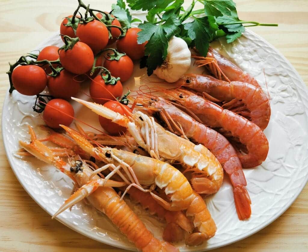 Ingredients for prawn and scampi pasta on white plate
