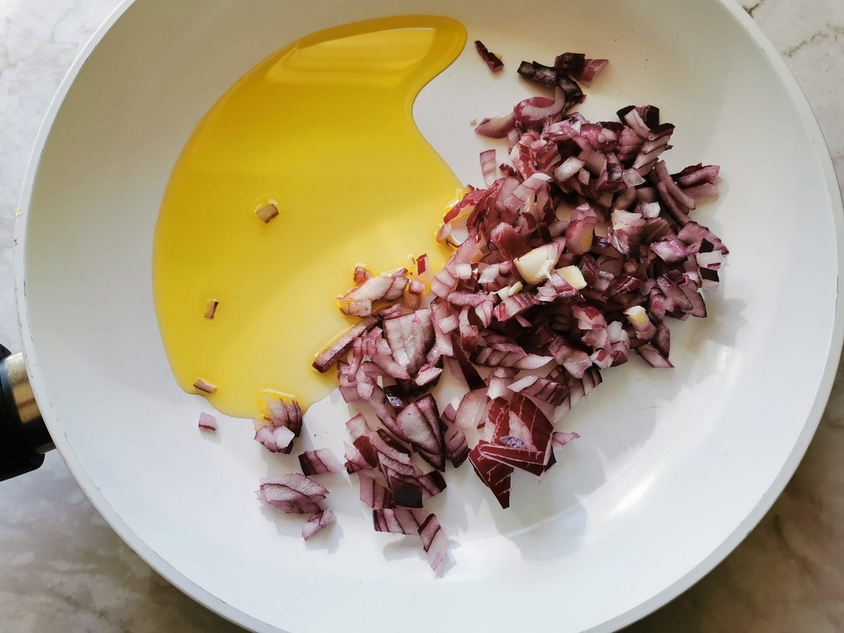 peeled and chopped onion in frying pan with olive oil