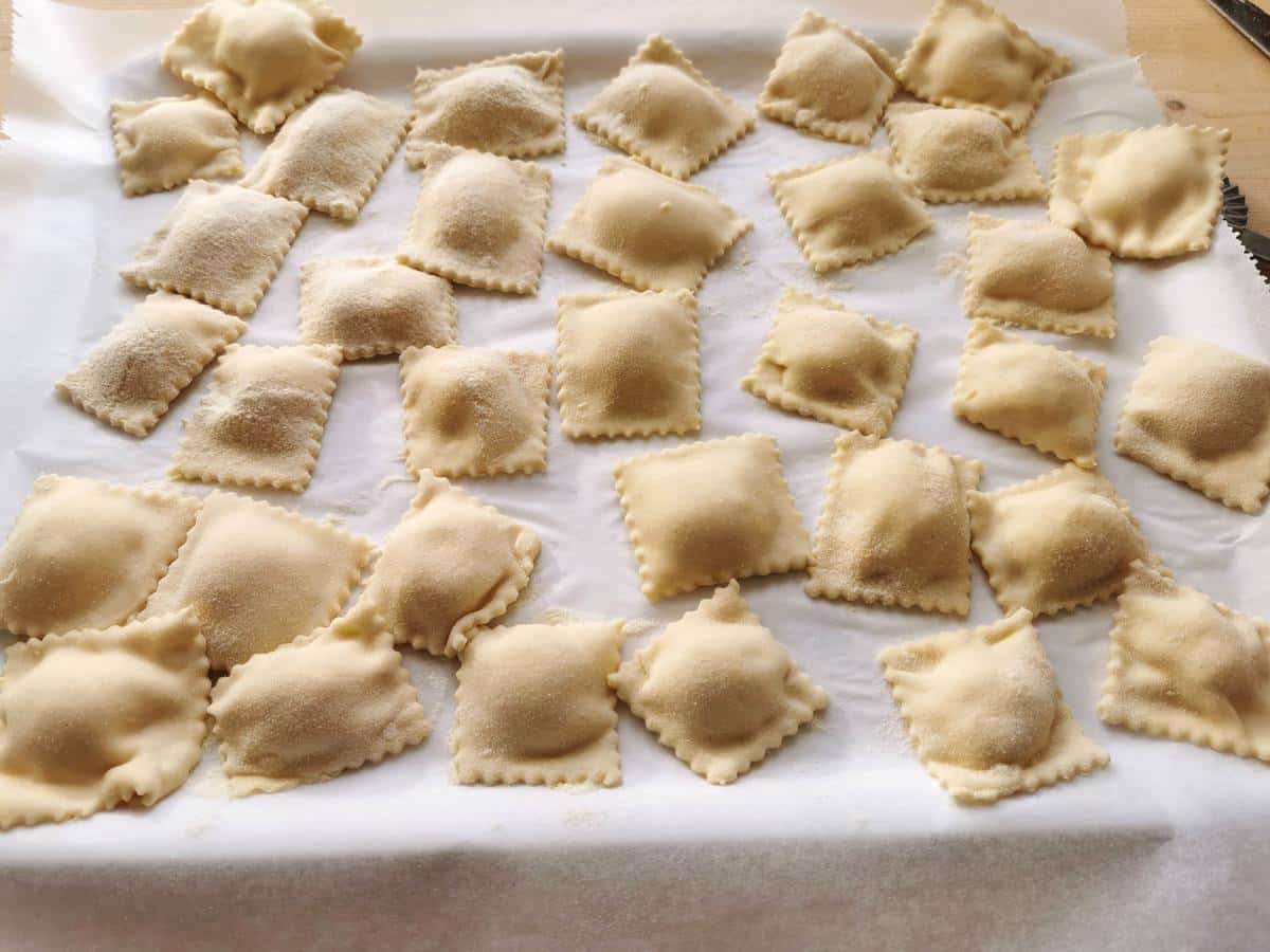 Ready ricotta ravioli on floured tray