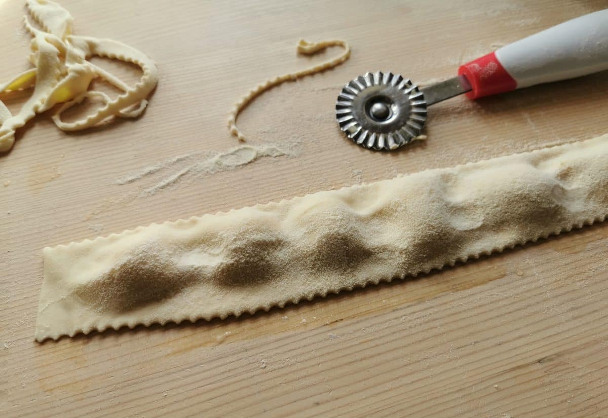 Extra pasta dough cut away using a  circular pastry cutter