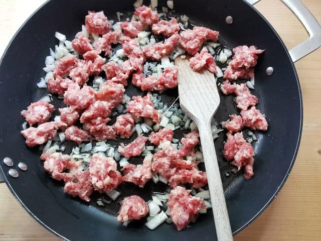 sausage meat and onions cooking in skillet