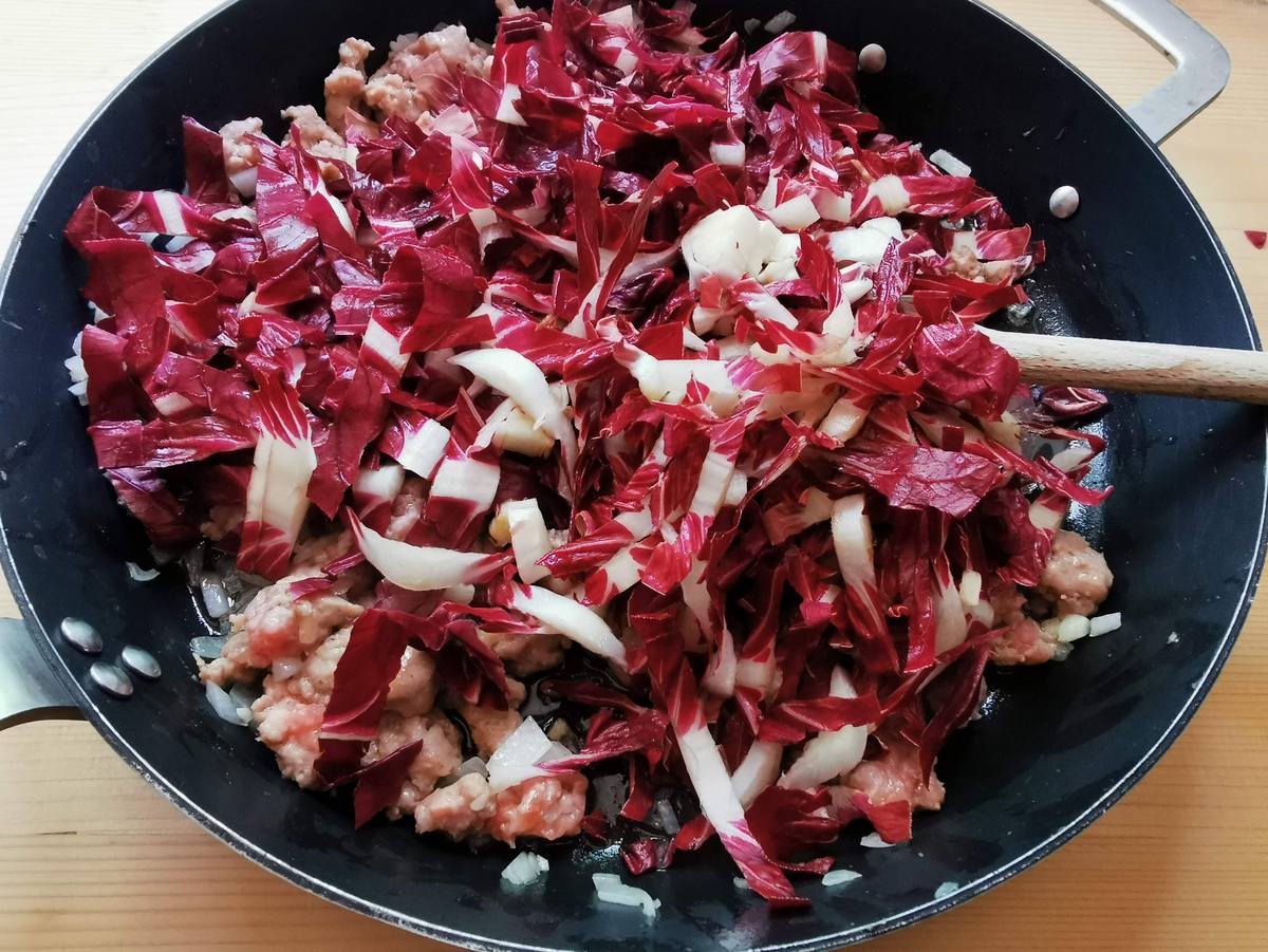 Chopped radicchio cooking in skillet with shallots.