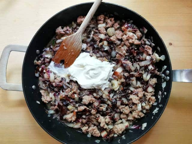 heavy cream added to sausage and radicchio in skillet