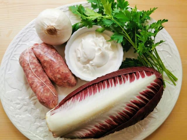 ingredients for sausage and radicchio pasta on white plate