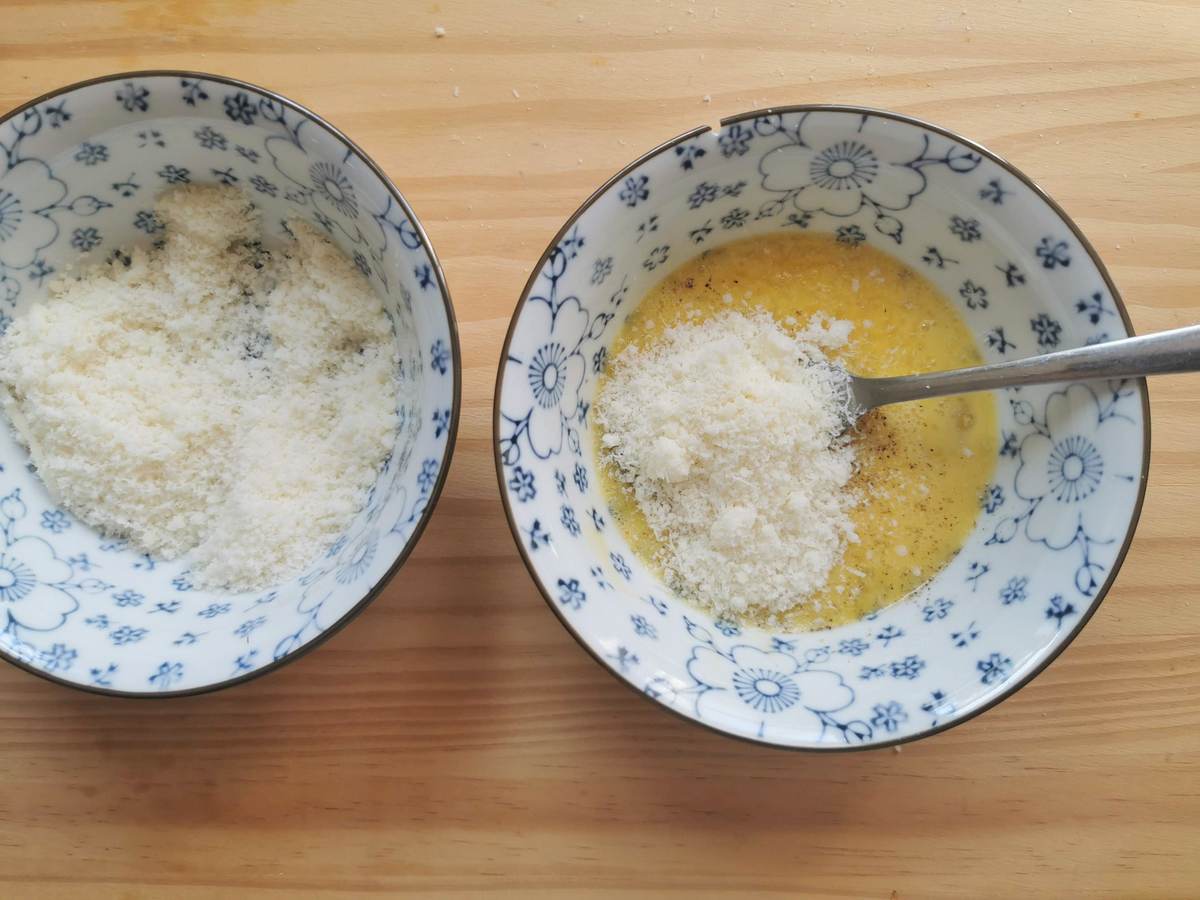 Beaten egg yolks with grated pecorino in small bowl with fork.