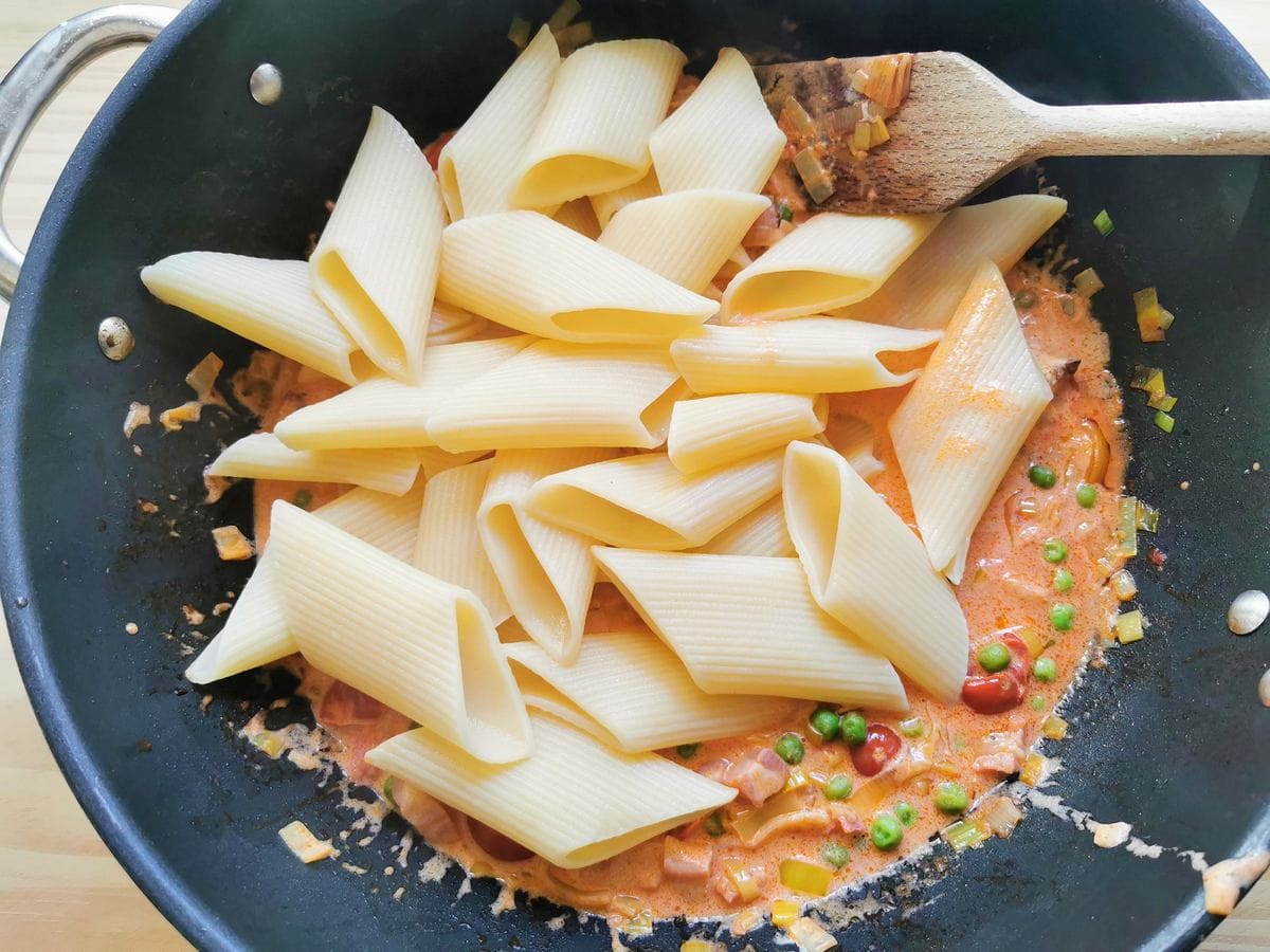Cooked large penne in skillet with seven Ps pasta sauce.