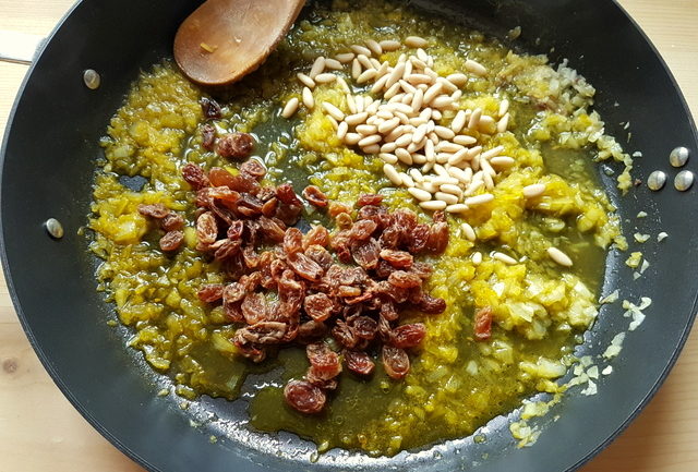 onions, saffron, raisins and pine nuts in frying pan