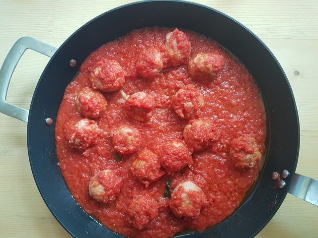 fresh tuna meatballs cooking in tomato sauce in skillet