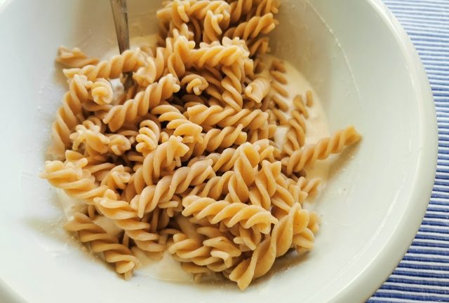 cooked fusilli in white bowl with ricotta