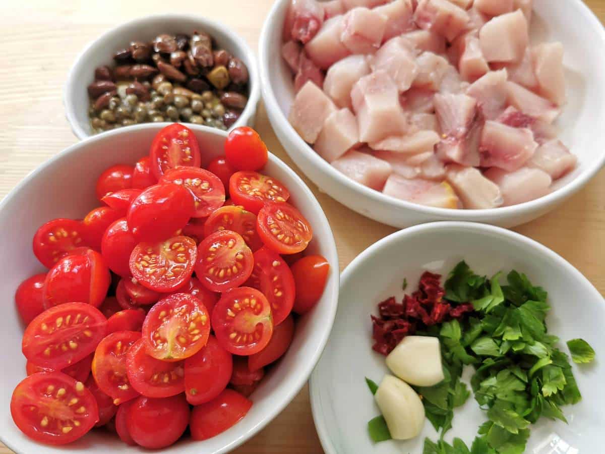 tomatoes, swordfish, and other ingredients prepared for cooking