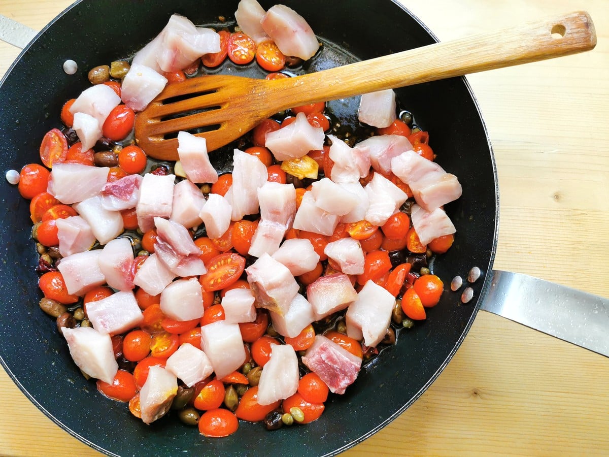 swordfish in skillet with tomatoes, olives and capers