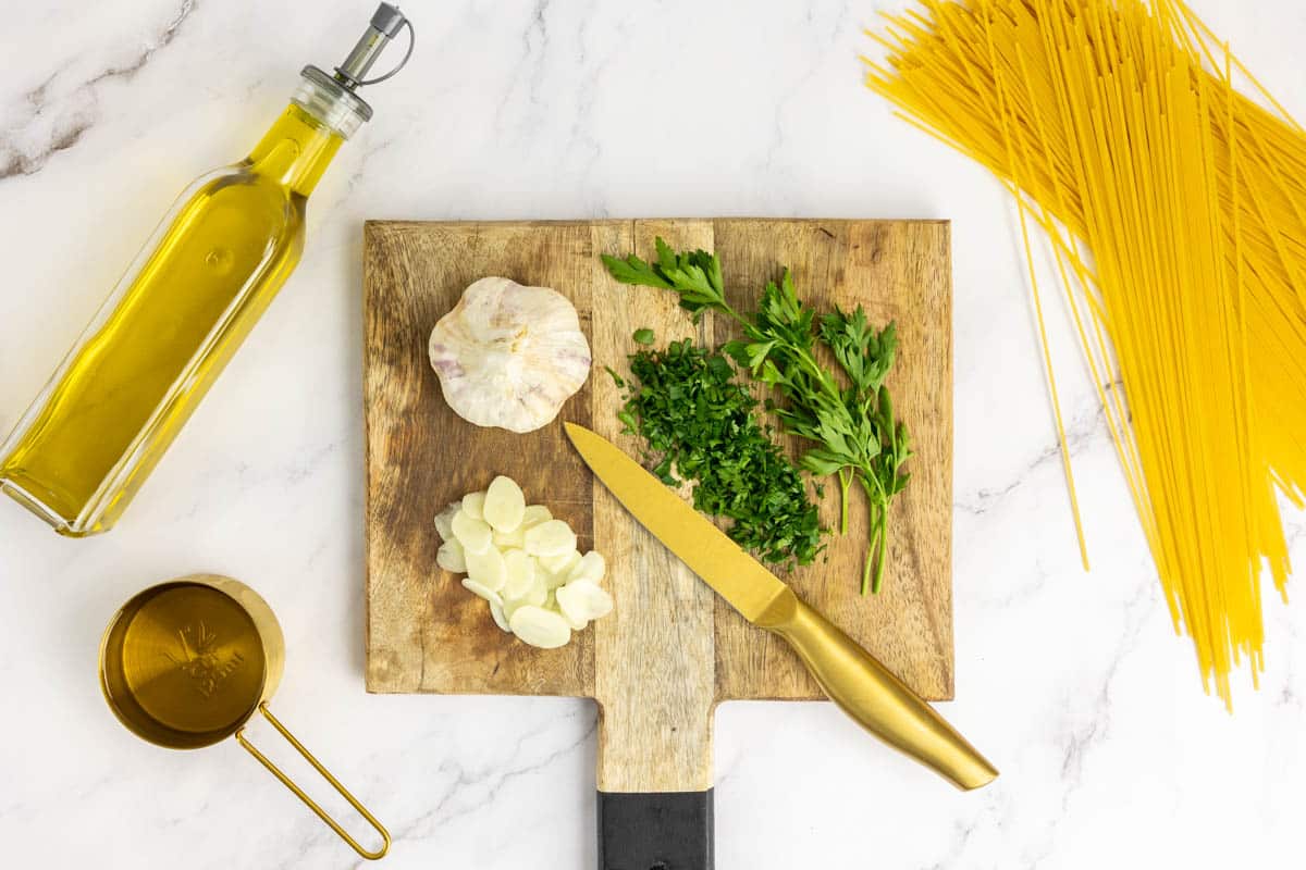 Ingredients to make pasta aglio e olio: Spaghetti, garlic, parsley, extra virgin olive oil