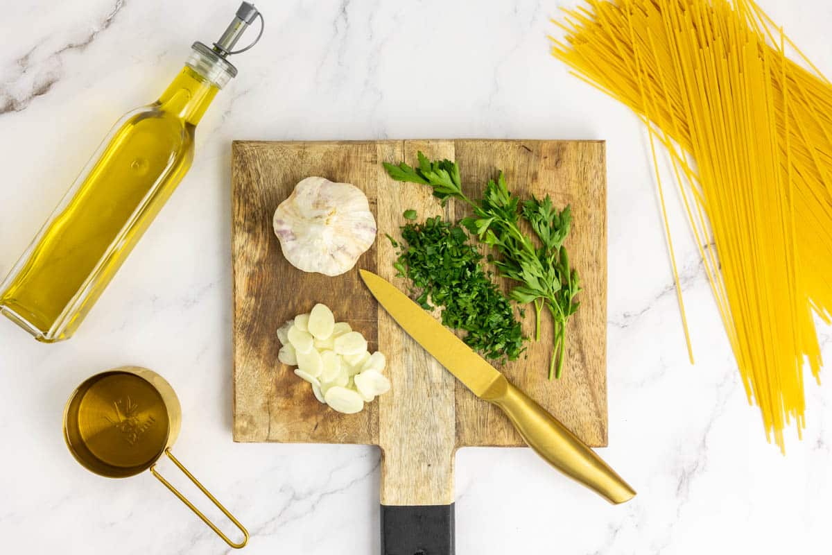 Ingredients to make pasta aglio e olio: Spaghetti, garlic, parsley, extra virgin olive oil