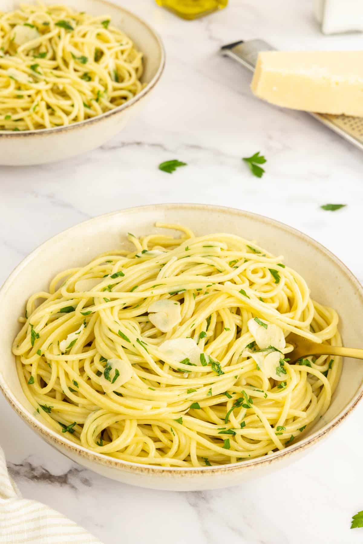 Spaghetti aglio e olio in a bowl with a fork starting to life some pasta out