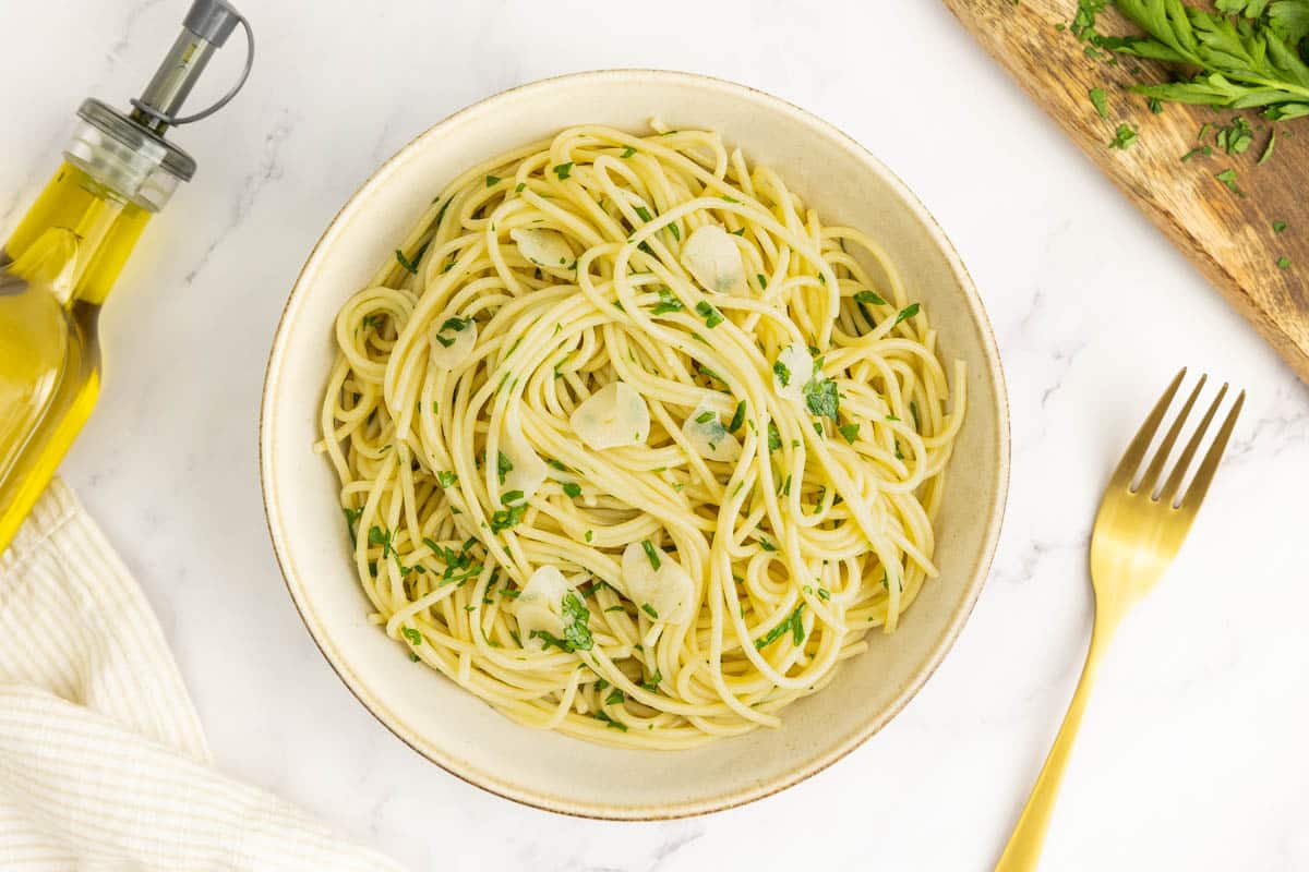 Spaghetti aglio e olio in a bowl with a fork, garnished with fresh parsley