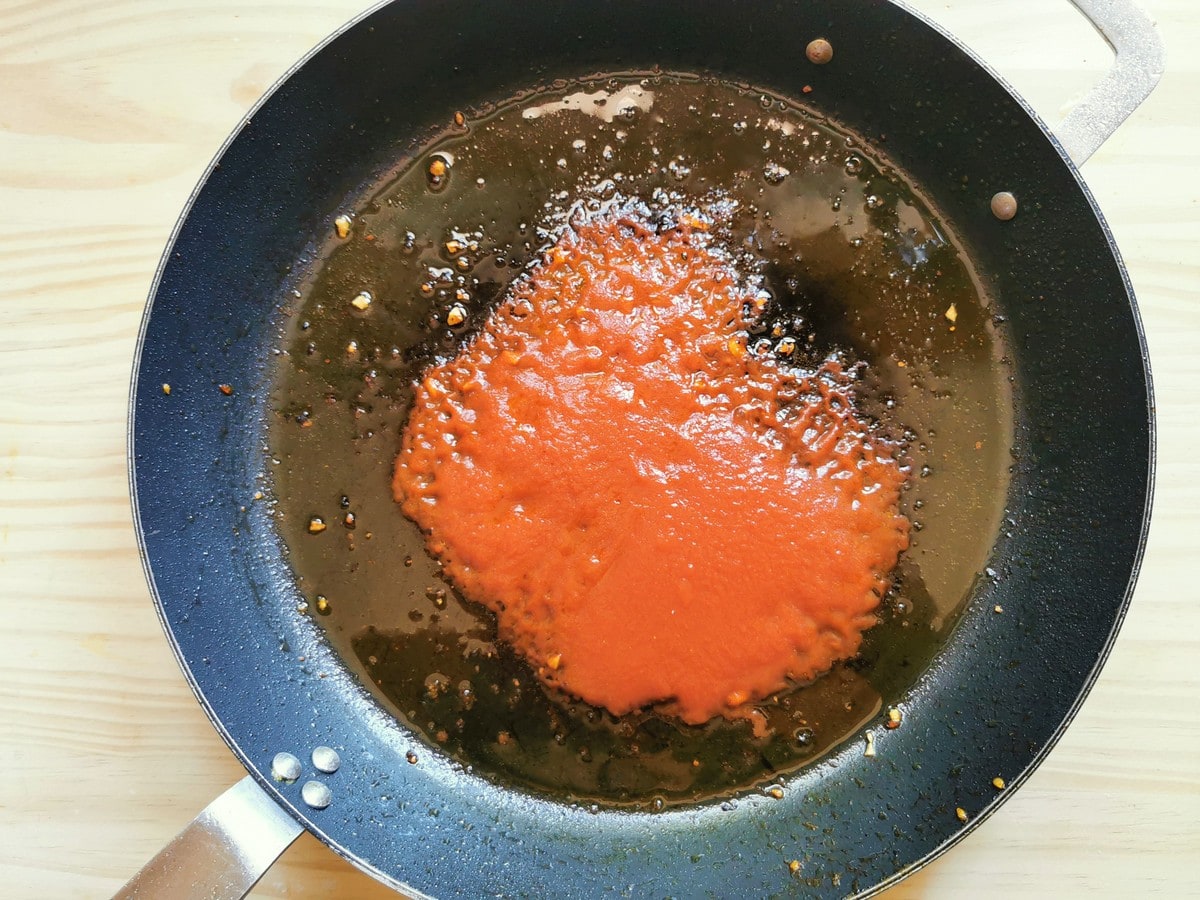 Tomato passata in cast iron skillet with sautéed garlic and red chili flakes.