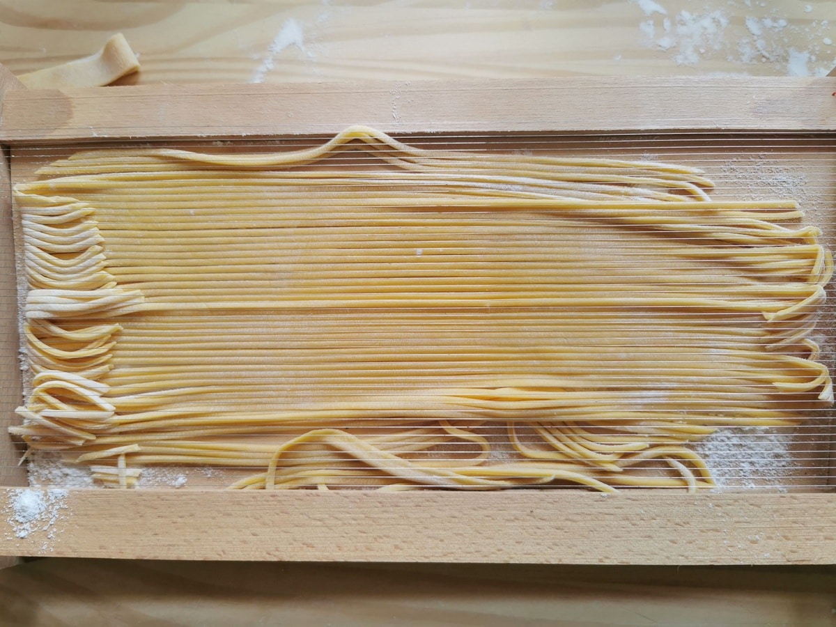 Ready spaghetti alla chitarra still inside the pasta tool.