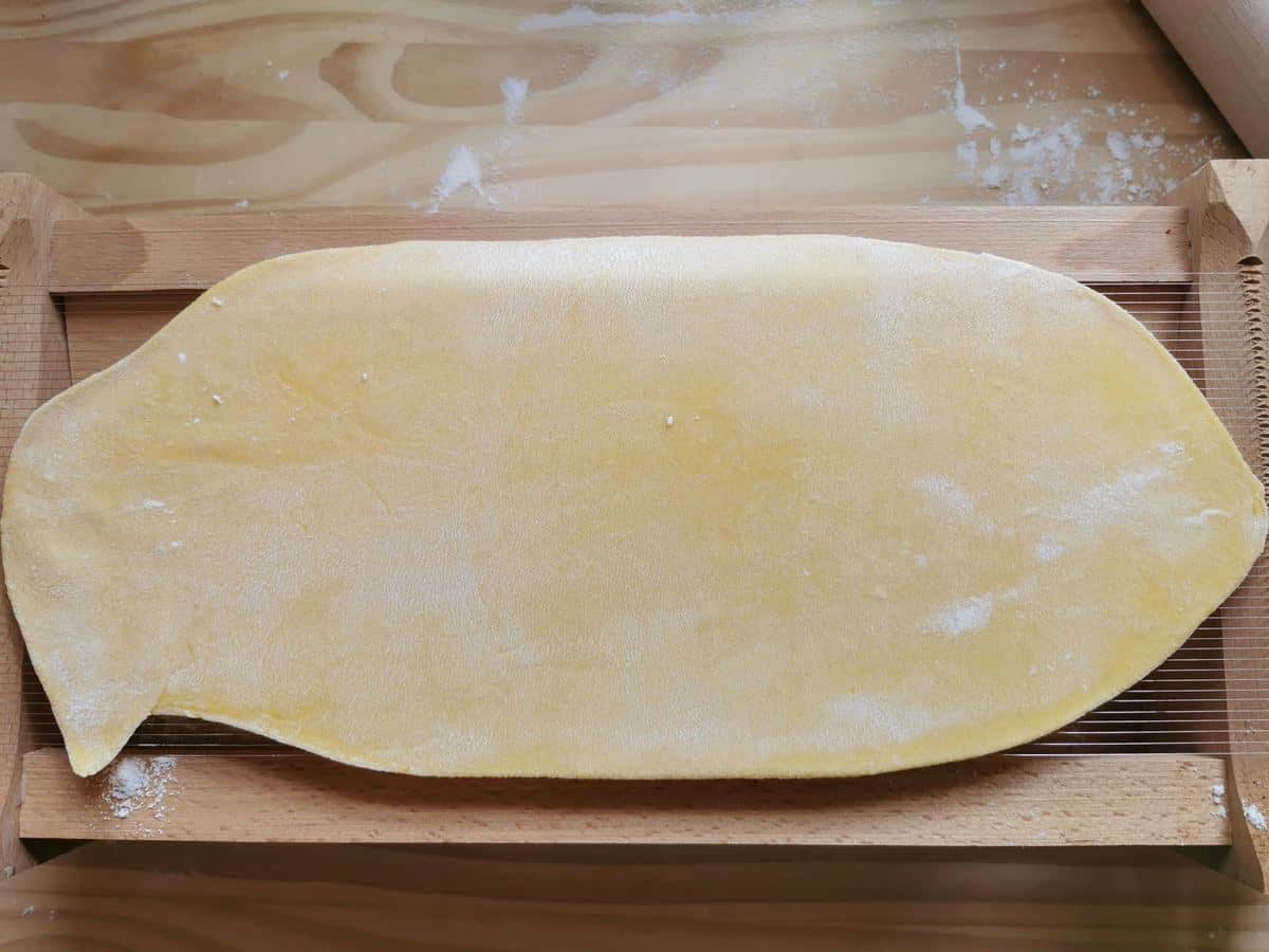 Sheet of pasta dough placed on a chitarra.