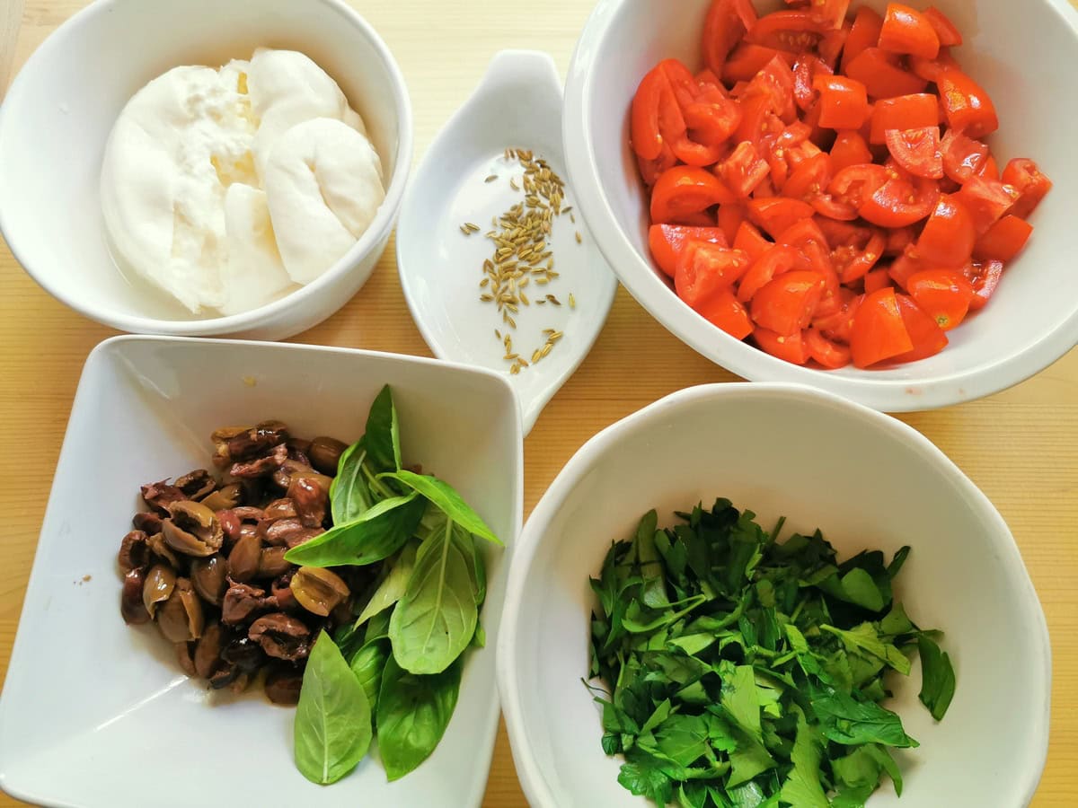 Prepared ingredients for spaghetti alla checca in white bowls.