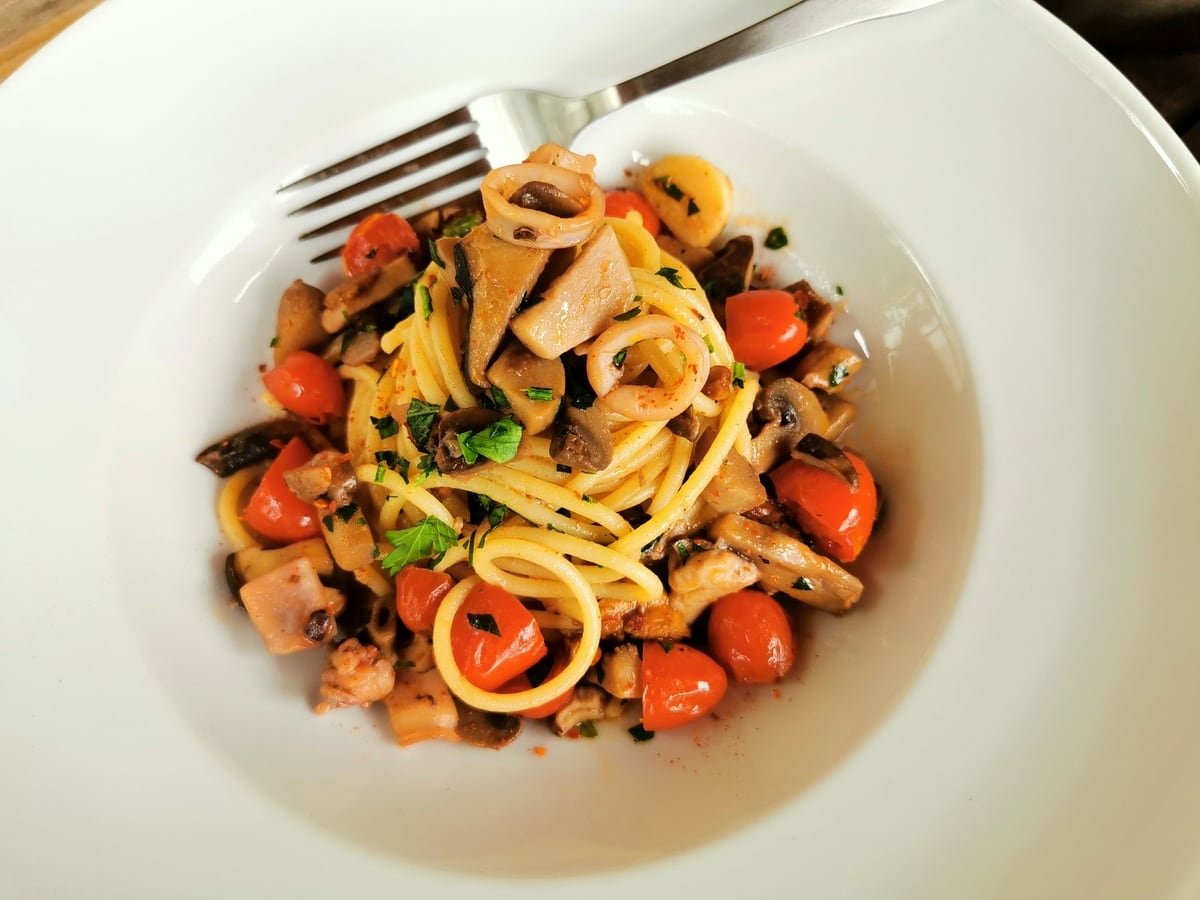 Spaghetti mare e monti garnished with sliced parsley