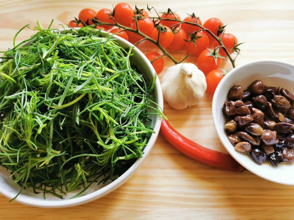 ingredients for agretti spaghetti on wood board