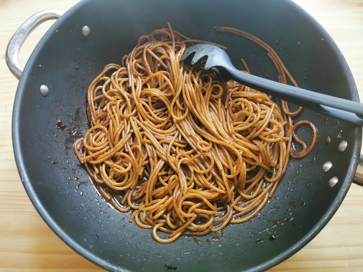 Spaghetti cooked risotto style in black garlic sauce in skillet.