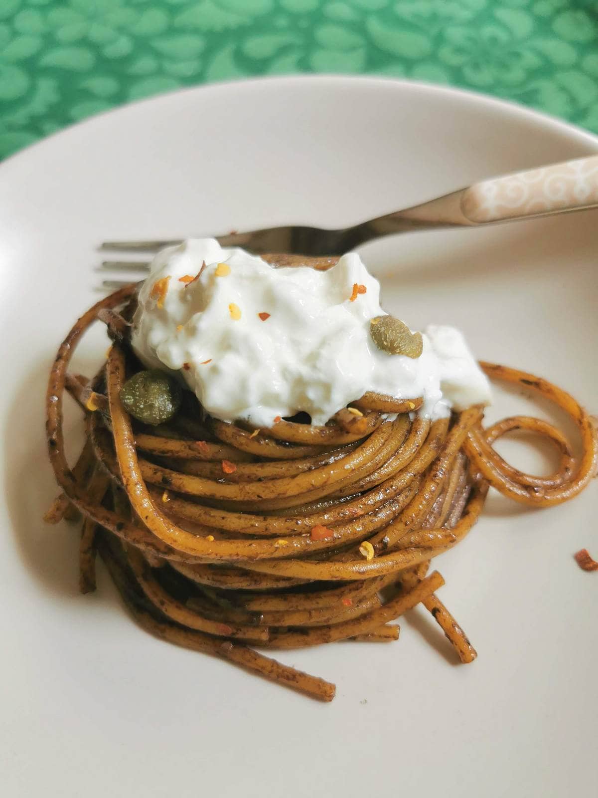 Spaghetti with black garlic sauce and burrata.