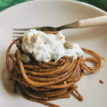 Spaghetti with black garlic sauce and burrata.