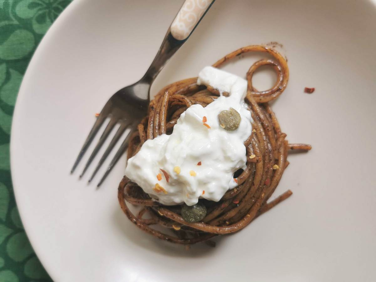 Spaghetti with black garlic sauce and burrata.