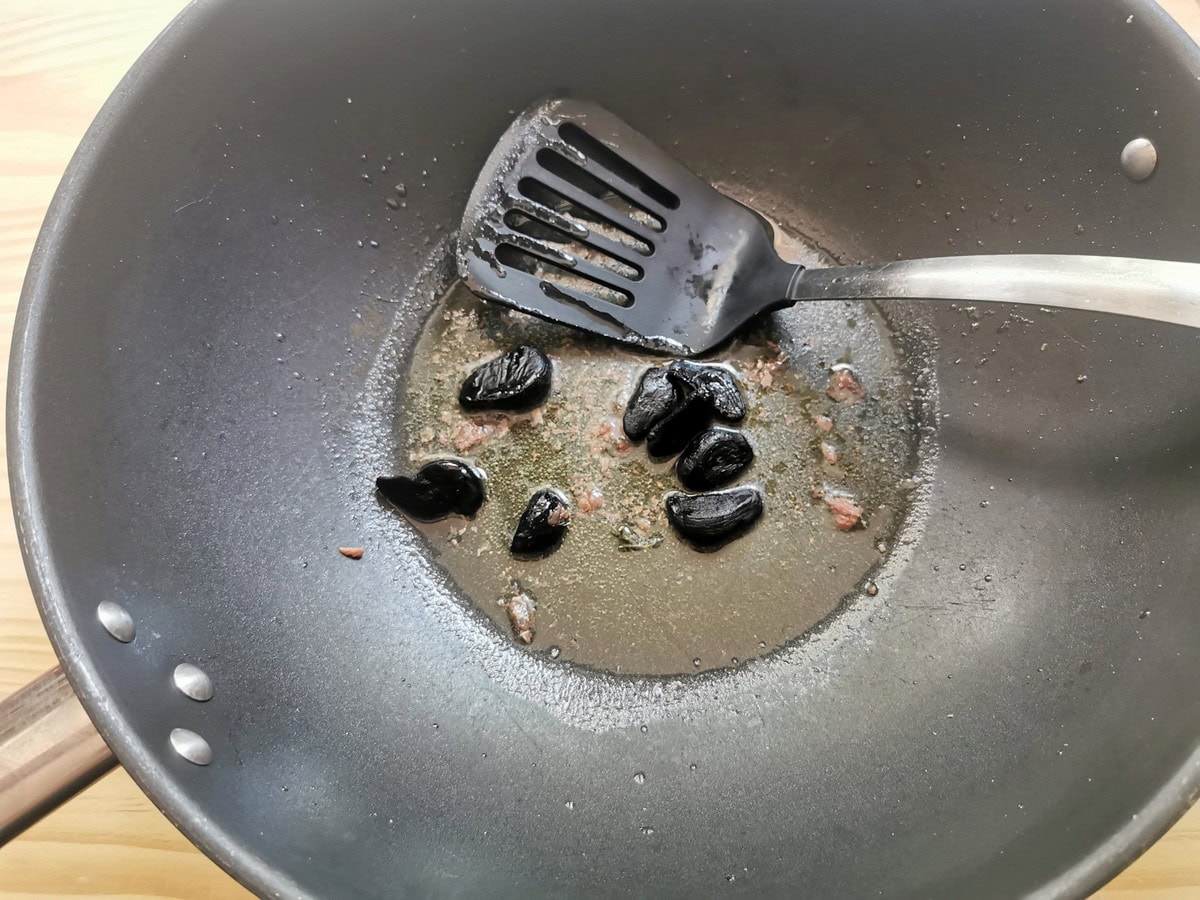 Dissolved anchovies in large skillet with olive oil and black garlic cloves.