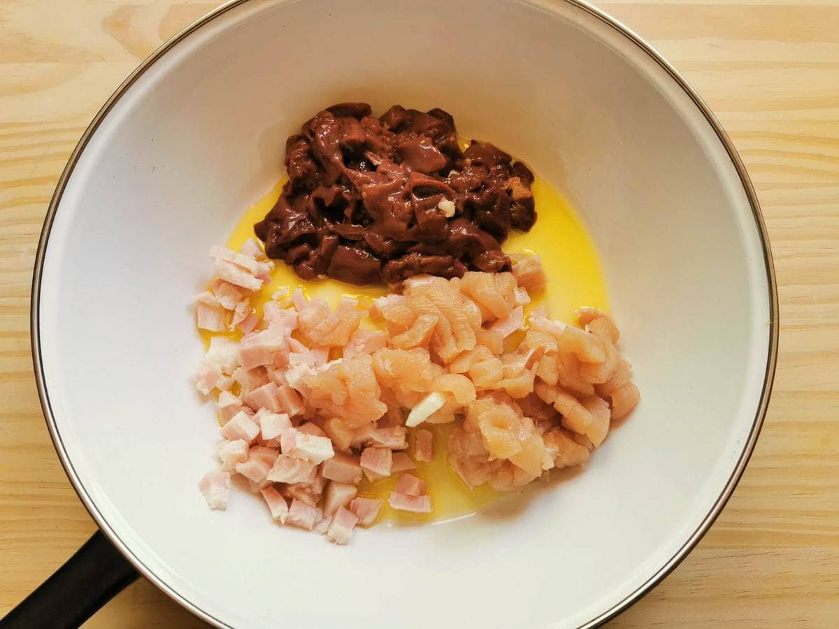 chopped chicken livers, turkey breast and ham in frying pan with olive oil